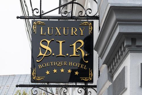 um sinal para um hotel de luxo pendurado na lateral de um edifício em SIR LUXURY BOUTIQUE HOTEL em Braila