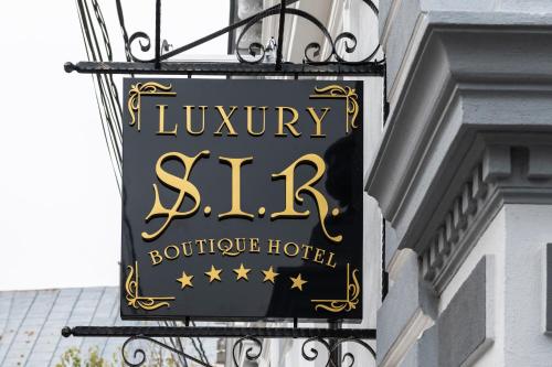 a sign for a luxury hotel hanging on the side of a building at SIR LUXURY BOUTIQUE HOTEL in Brăila