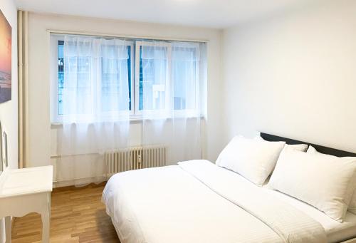 - une chambre avec un lit blanc et une fenêtre dans l'établissement Lucerne Apartment - near lion monument - by PAF, à Lucerne