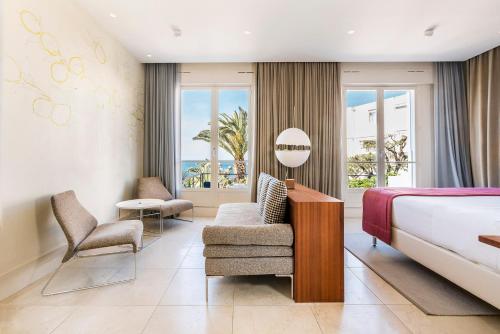 une chambre d'hôtel avec un lit et une chaise dans l'établissement Le Petit Nice - Passedat, à Marseille