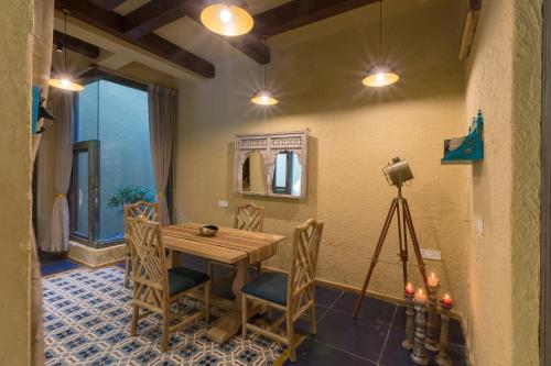 a dining room with a table and chairs and a camera at Vannraj Resort And Spa in Khawāsa