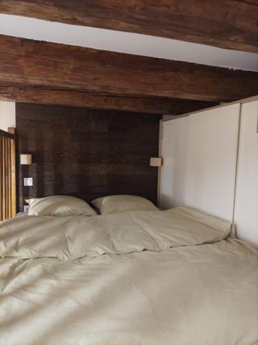 a large white bed with a wooden head board at Chorni vivtsy in Chernivtsi
