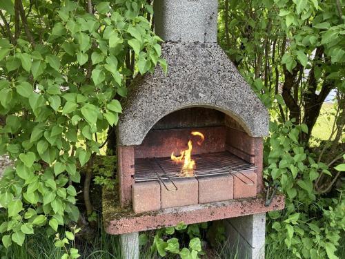 a brick oven with a fire inside of it at Spacious apartment in old farm close to Lac de Vouglans in La Tour-du-Meix