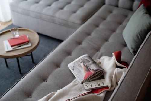 a magazine laying on a couch with a table at Hotel Schwarzschmied in Lana