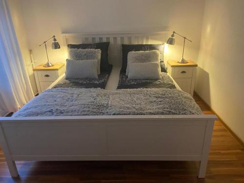 a large white bed with two lamps on both sides at Lux Plus apartament Chodzież, Zwycięstwa 13 in Chodzież