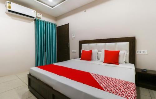 1 dormitorio con 1 cama grande con almohadas rojas en MALAYA HOUSE --Couples, Family, Corporate Favorite-- Near BMC Chowk ICONIC Mall, en Jalandhar