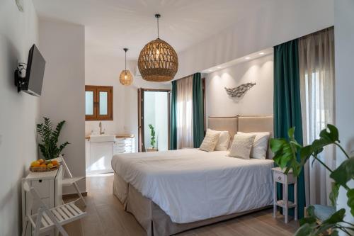 a bedroom with a white bed with green curtains at Lemon Garden Residence in Heraklio