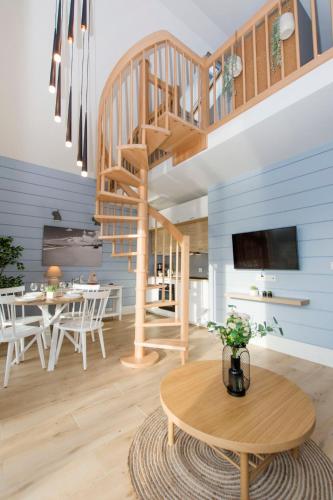 a living room with a wooden staircase and a table at Słoneczna Przystań - Apartamenty dwupoziomowe in Sobieszewo