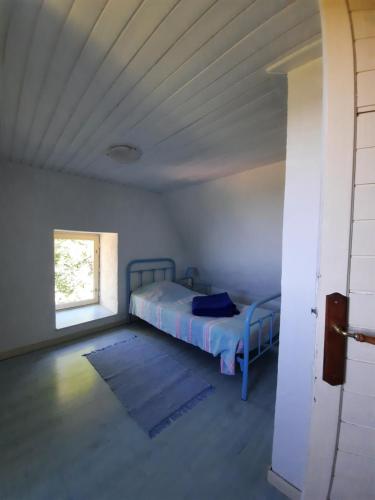 ein Schlafzimmer mit einem Bett in einem Zimmer mit einem Fenster in der Unterkunft Lou Cantou in Marnac