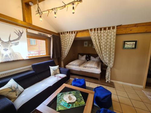 ein Wohnzimmer mit einem Sofa und einem Bett in der Unterkunft Verena's Parkhotel in Löffingen