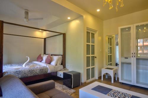 a bedroom with a bed with a large mirror at Pajaros Blu in Calangute