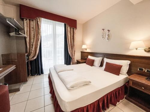 a hotel room with a large bed in a room at Hotel Oasi Beach in Malcesine