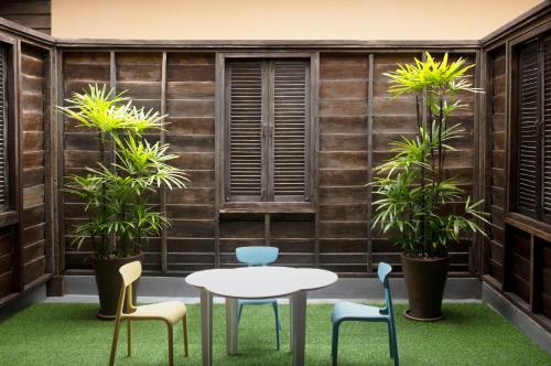 a patio with a table and chairs and plants at Buri Rasa Village Phangan in Thong Nai Pan Noi