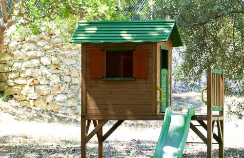 une maison ornithologique sur un stand à côté d'une chaise dans l'établissement Luxury Crete Villa Villa Melpomeni Private Pool Private Playground 5 BDR Rethymno, à Vederoi