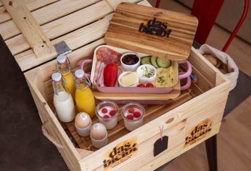 a wooden box with food and drinks in it at das bleibt Alpine Suites in Schladming