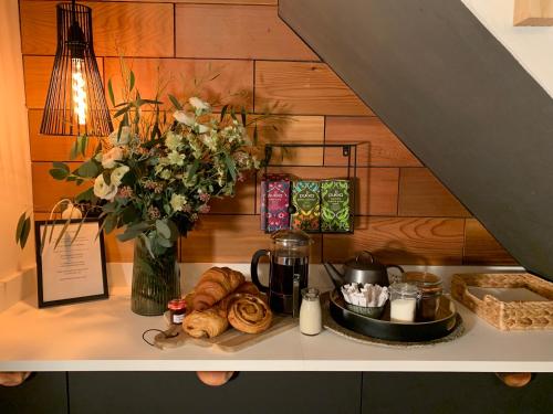 a shelf with a vase of flowers and bread at 4 Danes Cottages - perfect location in Lincoln