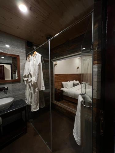 een badkamer met een douche, een bed en een wastafel bij Namdul Retreat in Phensāng