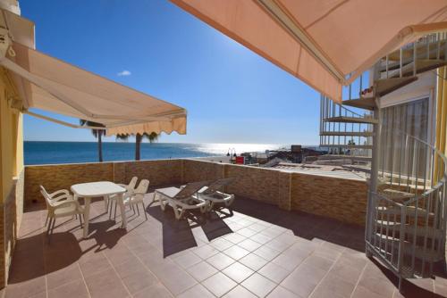 a patio with a table and chairs and the beach at CARIHUELA 1ª LÍNEA DE PLAYA in Torremolinos