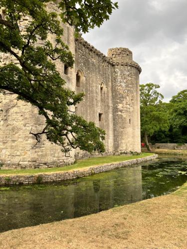 an old castle with a river in front of it at Valley View Farm, Bed and Breakfast in Batcombe
