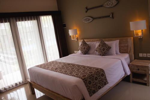 a bedroom with a large bed with white sheets and pillows at Kubu Garden Suites & Villas Nusa Dua in Nusa Dua