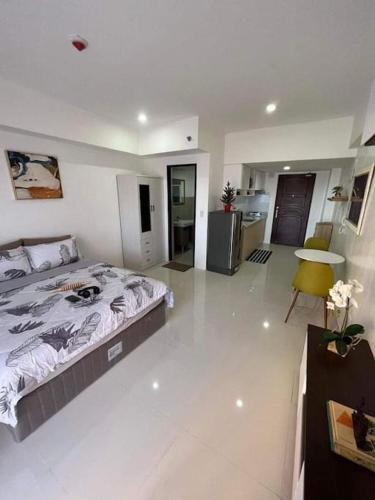 a bedroom with a large bed and a kitchen at 88Minesview LODGE By SUNTRUST CONDOMINIUM in Baguio