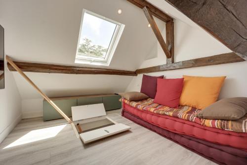 a living room with a red couch and a window at Villa l'Hermitage Piscine Sauna Fitness Deauville in Bénerville-sur-Mer