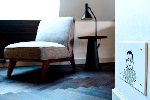 a chair and a lamp in a living room at The Lubo - self check-in in Luzern