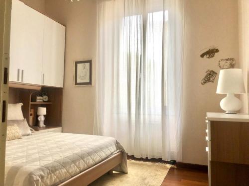 um quarto com uma cama e uma janela com cortinas brancas em Ca' de Lu em Savona