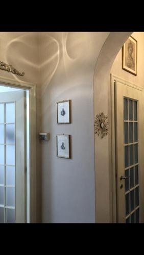 um corredor com três imagens na parede e uma porta em Ca' de Lu em Savona