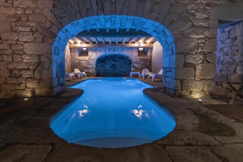 una piscina cubierta en un edificio de piedra con un arco en Manoir des Indes, The Originals Relais (Relais du Silence), en Quimper