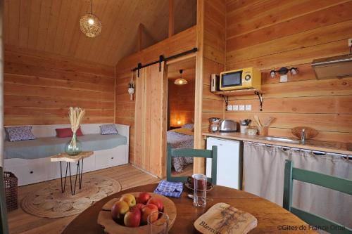 a kitchen and dining room with a table in a cabin at LA CABANE DE JABI in Trémont
