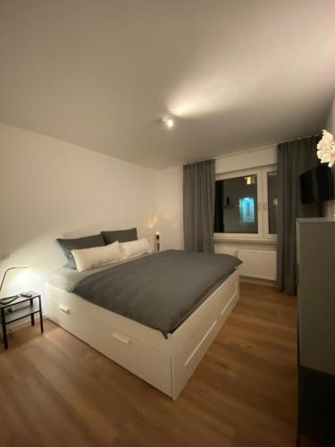 Un dormitorio con una gran cama blanca y una ventana en Ferienwohnung K1957 - Dutum, en Rheine