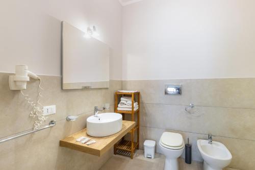 a bathroom with a sink and a toilet and a mirror at Nonna Nina in Avola