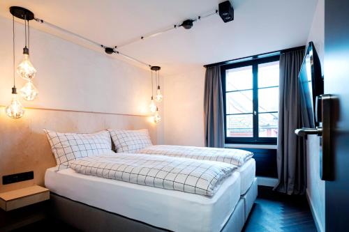 a bedroom with a white bed with lights on it at The Lubo - self check-in in Luzern