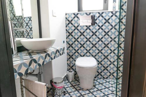 a bathroom with a toilet and a sink at Community Rooms & Wine in Favara