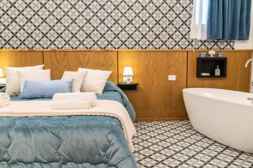 a bedroom with a bed and a bath tub at Community Rooms & Wine in Favara