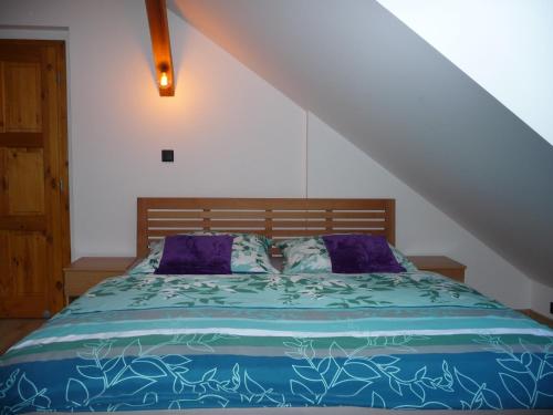 a bedroom with a bed with a blue comforter at Penzion Kozák in Český Krumlov