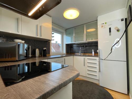 a kitchen with white cabinets and a refrigerator at Stavanger Bnb nicolas 10 Terrace 2bed Rooms in Stavanger