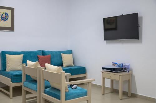 a living room with a blue couch and a tv at Manuel's Dream in Ádhele
