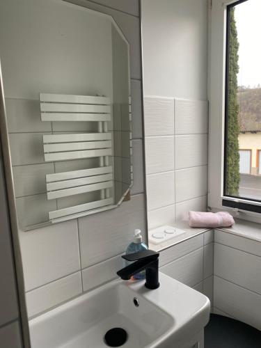 a white bathroom with a sink and a mirror at Monteur- und Ferienwohnung in Neuenhof