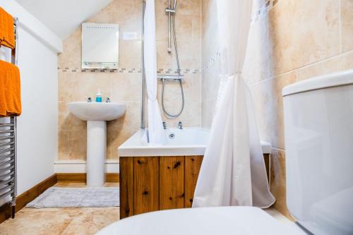 a bathroom with a sink and a shower and a toilet at Thursdays Corner Tudor Cottage in Church Stretton