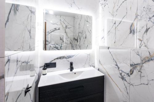 a white bathroom with a sink and a mirror at Lundur Apartments - Down Town in Reykjavík