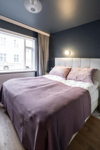 a bedroom with a large bed and a window at Lundur Apartments - Down Town in Reykjavík