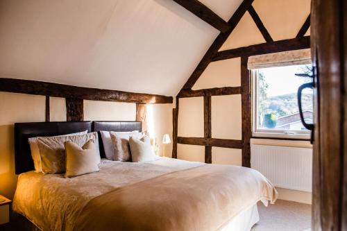 a bedroom with a large bed and a window at Thursdays Corner Tudor Cottage in Church Stretton