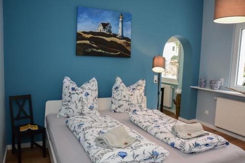 ein blaues Zimmer mit einer Couch mit Kissen in der Unterkunft Gartenblick in Leichlingen