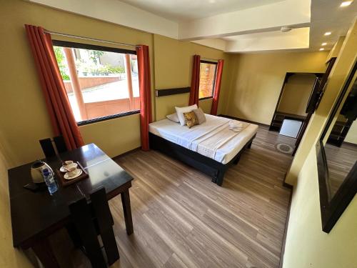 a room with a bed and a table and a window at Piña Colina Resort in Tagaytay