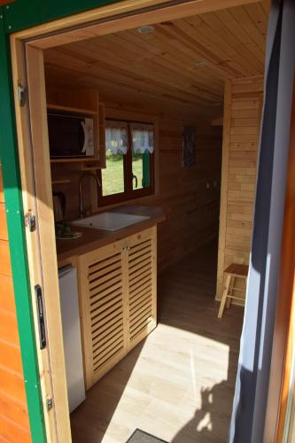 - une cuisine dans une cabane en rondins dotée d'une fenêtre dans l'établissement Les Roulottes des Ris, à Vallon-en-Sully