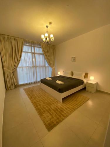 a bedroom with a bed and a large window at Modish Classy Apartment In Jumeirah in Dubai