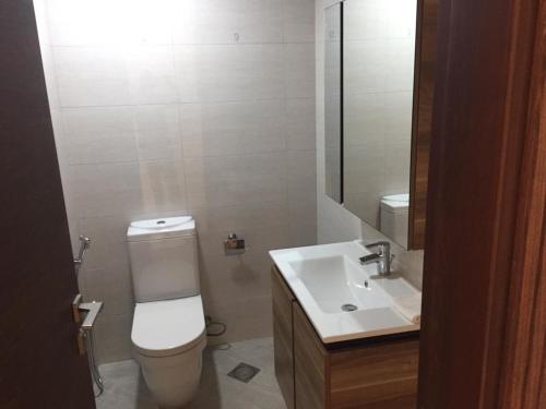 a bathroom with a white toilet and a sink at Modish Classy Apartment In Jumeirah in Dubai
