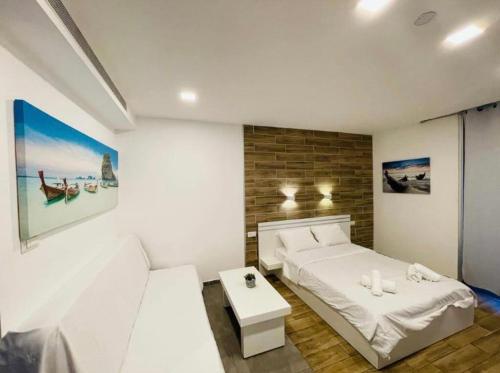 Dormitorio blanco con cama y mesa en Eilat Charming Studio-Balcony en Eilat